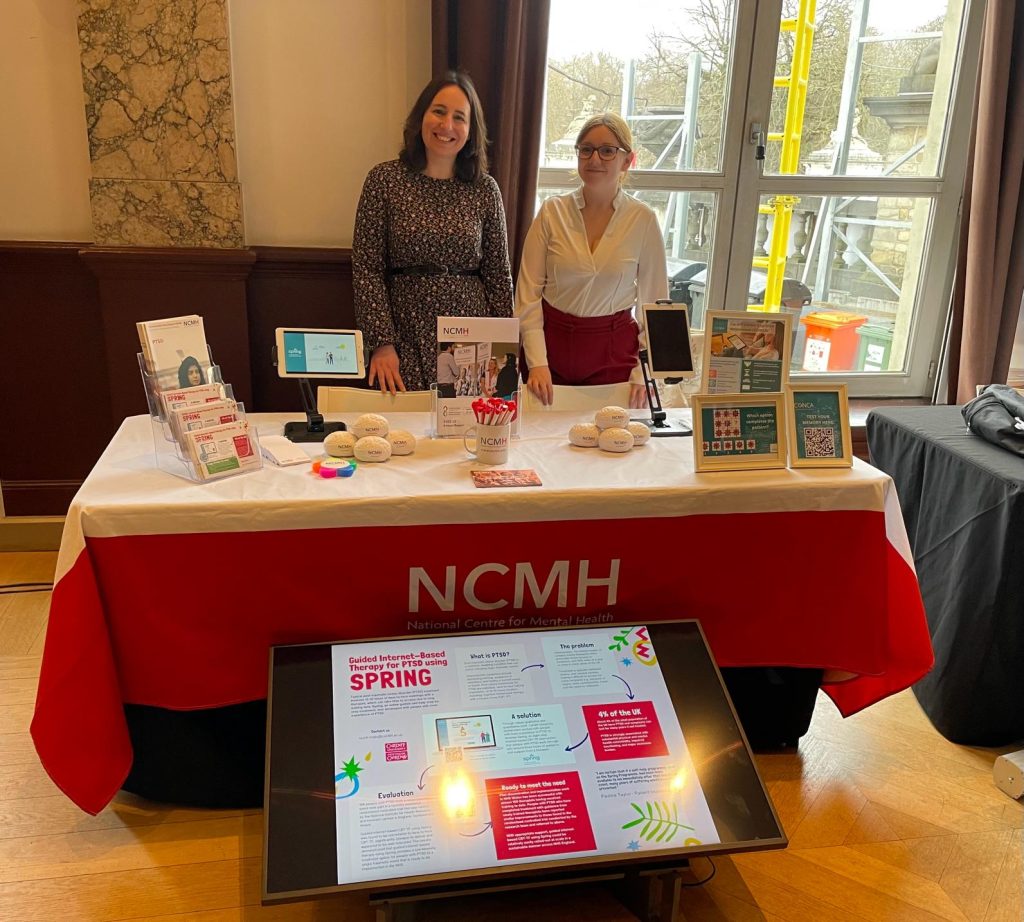 Picture of Dr Catrin Lewis and Dr Amy Lynham presenting at the NCMH stand in Brussels