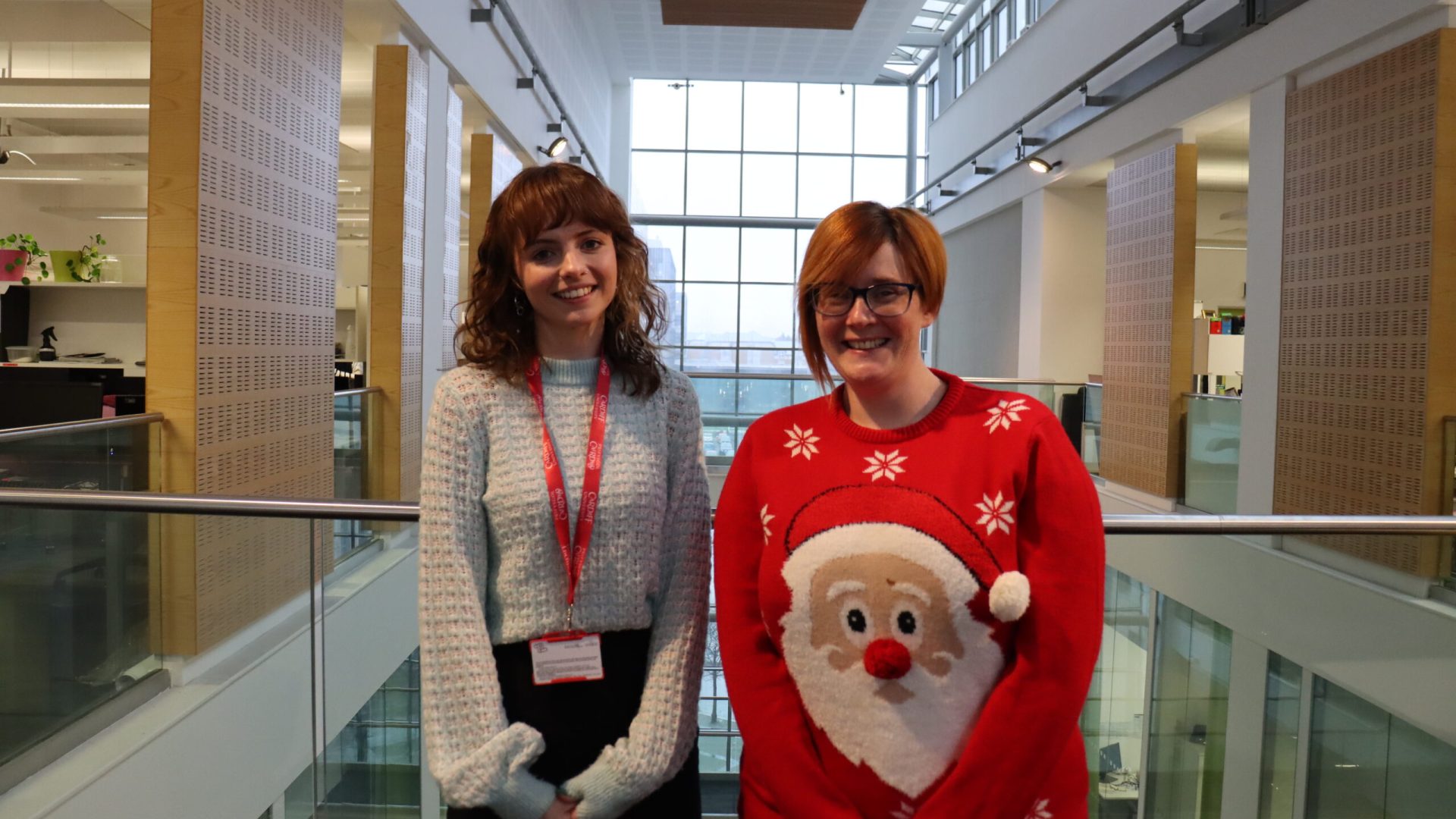 A photo of Chloe Apsey (left) and Becci (right) standing on the balcony of the Hadyn Ellis Building