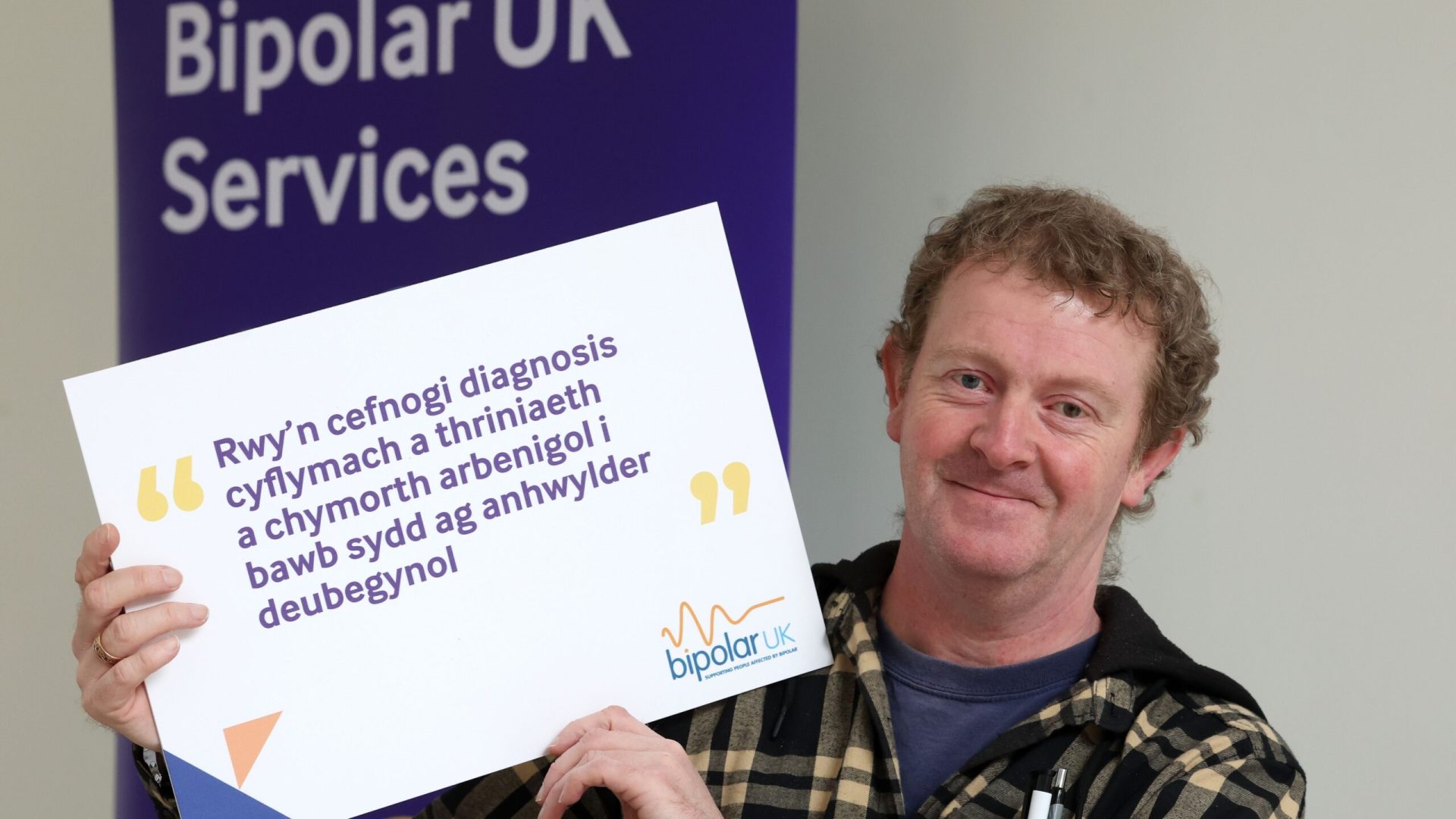 Photo of a gentleman holding a Bipolar UK Wales research pledge sign